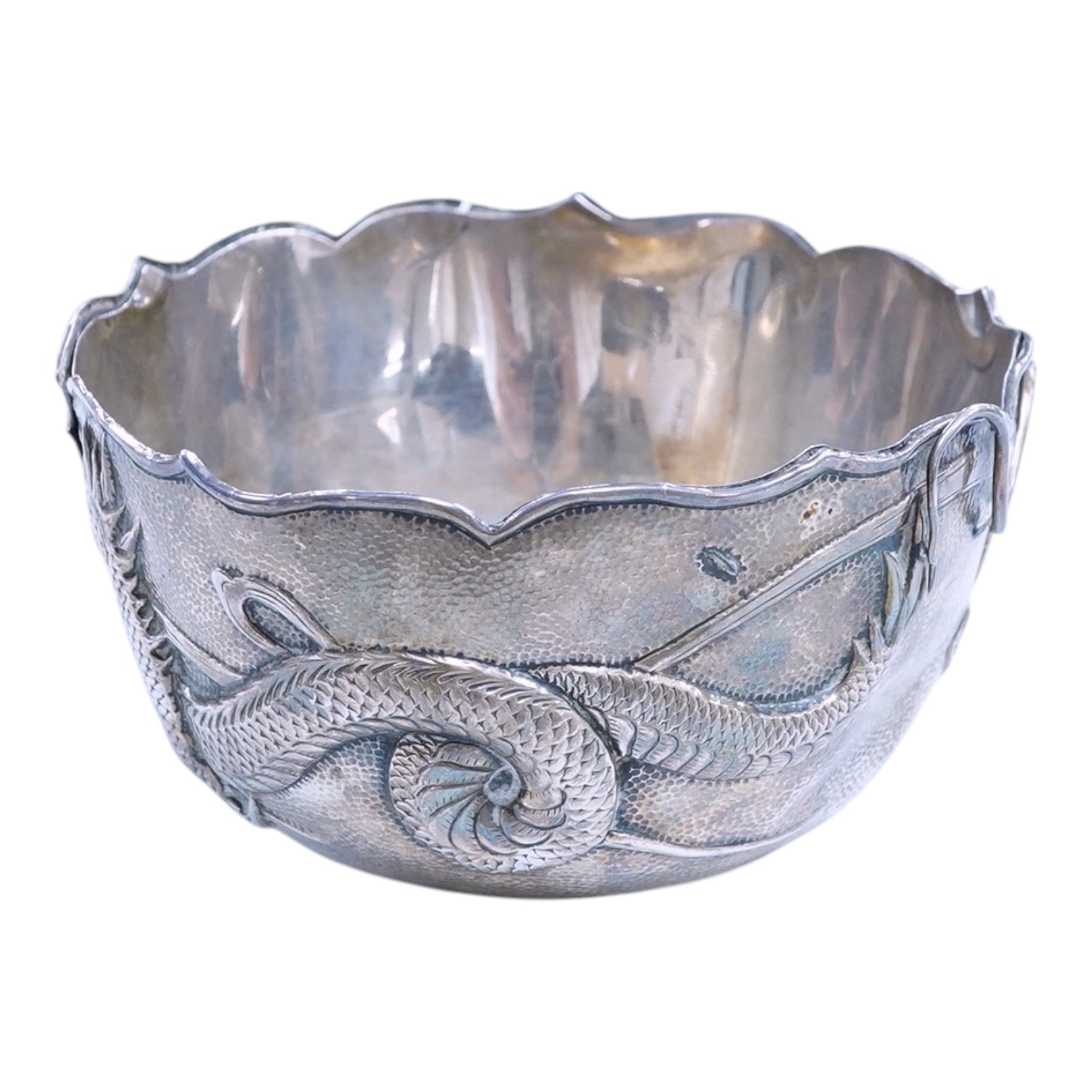 An early 20th century Japanese planished white metal double walled sugar bowl, decorated with the continuous scene of a dragon, signed to the base, diameter 12.1cm, 5.9oz(a.f.).